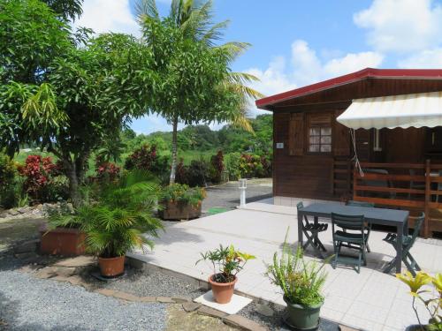 a patio with a table and a house at Bungalow des Palétuviers in Morne-à-lʼEau