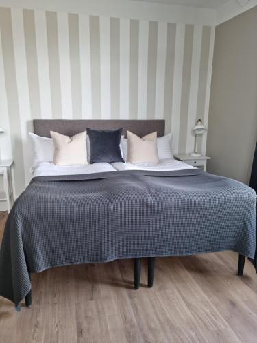 a bedroom with a large bed with black and white pillows at Hotell Stavstensgården in Trelleborg