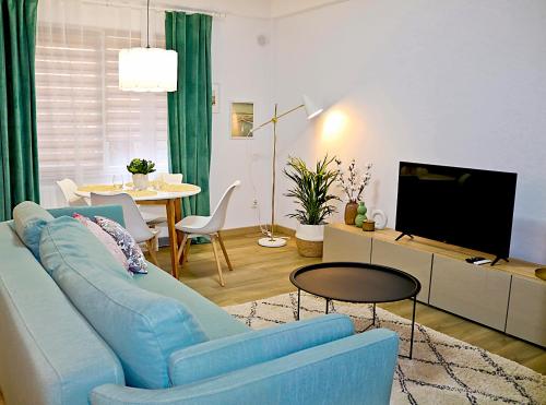 a living room with a blue couch and a tv at Evo Residence Migdalului in Cluj-Napoca