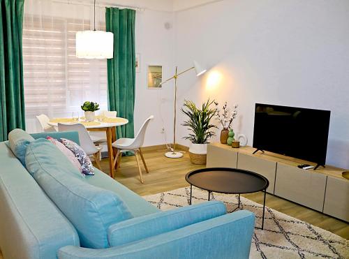 a living room with a blue couch and a tv at Evo Residence Taietura Turcului in Cluj-Napoca