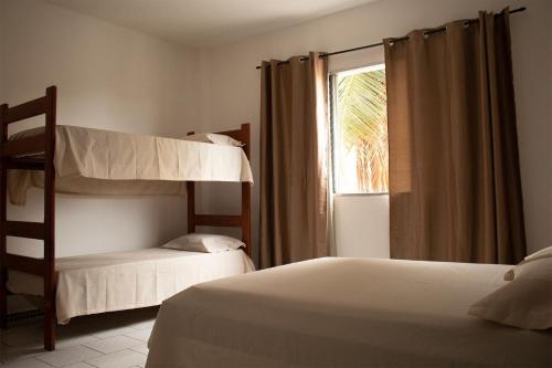 a bedroom with two bunk beds and a window at Solar Vila Mirim in Praia Grande