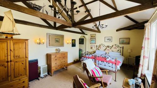 a bedroom with a bed and a wooden dresser at Sabine House - Waterside Historic Merchant House in Dartmouth