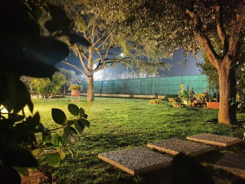 a park with trees and benches in the grass at Itaca in Lido di Fermo