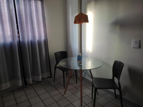 een tafel en twee stoelen en een lamp in een kamer bij Pertinho do mar 3 in João Pessoa