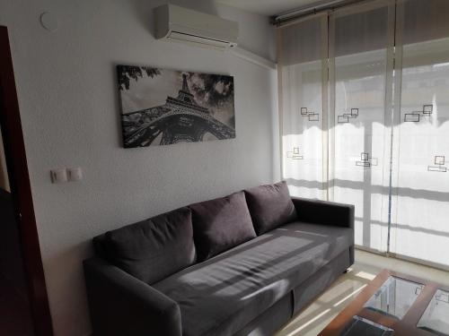 uma sala de estar com um sofá e uma imagem da torre Eiffel em Victoria Home Córdoba em Córdoba