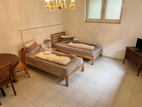 two beds in a room with a table and a dining room at kleines Häuschen in Alzenau in Unterfranken