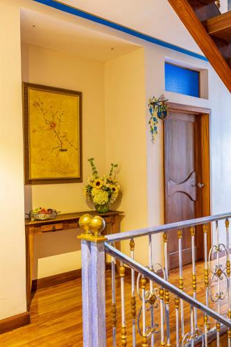 a hallway with a staircase with a door and a vase of flowers at Hotel Azul de la Plaza by Chat Noir in Cuenca