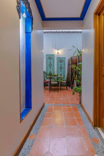 a hallway with a tile floor and blue ceilings at Hotel Azul de la Plaza by Chat Noir in Cuenca