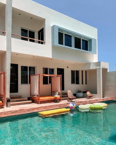a house with a swimming pool in front of a house at Shavanna Hotel Boutique in Puerto Escondido