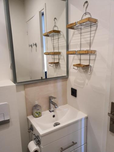 une salle de bain avec un lavabo et un miroir dans l'établissement Le yacht club1, à Blonville-sur-Mer