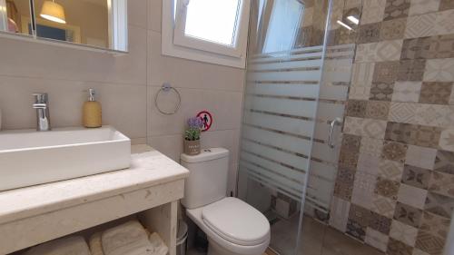 a bathroom with a toilet and a sink and a shower at Villa Marietta in Sidari