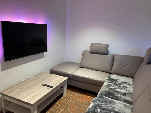 una sala de estar con un sofá y una mesa en Ferienhaus Nordstrand, en Horumersiel