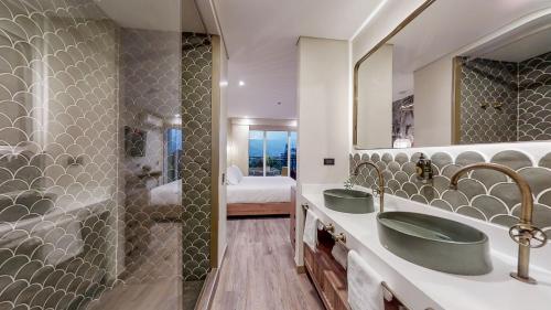 a bathroom with two sinks and a bed at Origen Hotel Boutique in Medellín