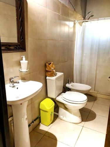 a bathroom with a toilet and a sink at CABAÑA DORADA in Villa Ciudad de América
