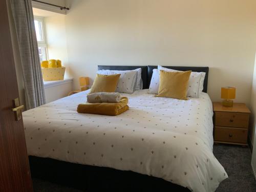 a bedroom with a large white bed with yellow pillows at Charming Parlour Cottage at Tinto Retreats near Biggar in Wiston