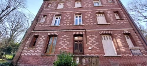a red brick building with white doors and windows at LE CISE EAU À bois in Le Bois de Cise