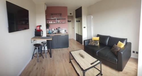 un salon avec un canapé et une table dans l'établissement Le yacht club1, à Blonville-sur-Mer