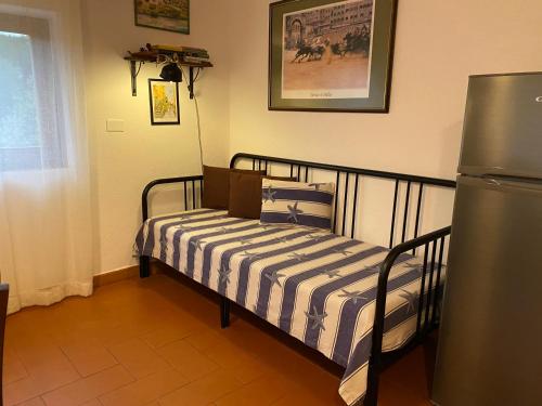 a small bed in a room with a refrigerator at Villa Paradisino in Orbetello