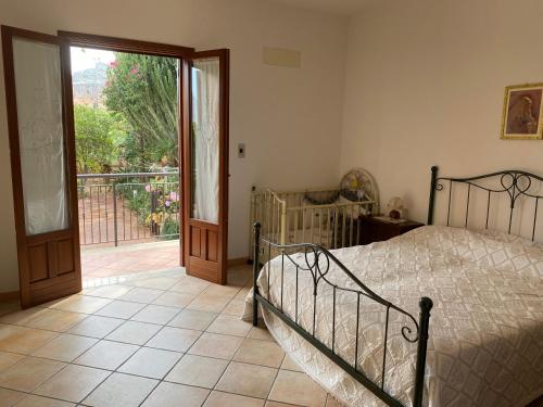 a bedroom with a bed and a sliding glass door at Villa dei Tramonti in Custonaci