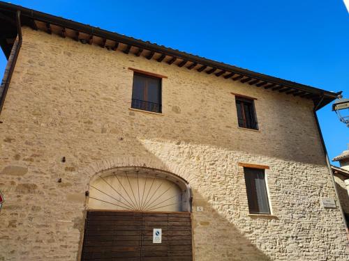 um grande edifício de tijolos com uma grande porta de garagem em Casa Vacanze del Console em Bevagna