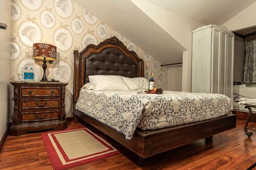 a bedroom with a large bed and a dresser at Hotel Azul de la Plaza by Chat Noir in Cuenca
