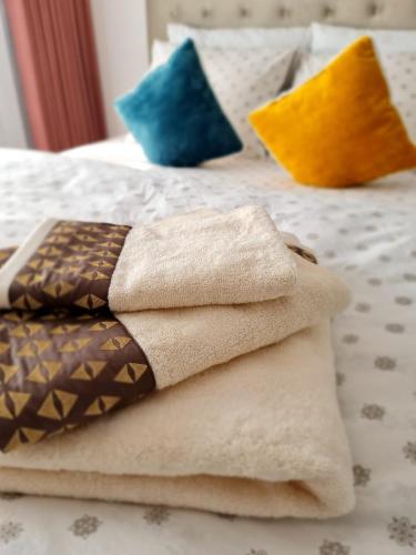 a pile of towels sitting on top of a bed at Stephanie Apartment in Galaţi