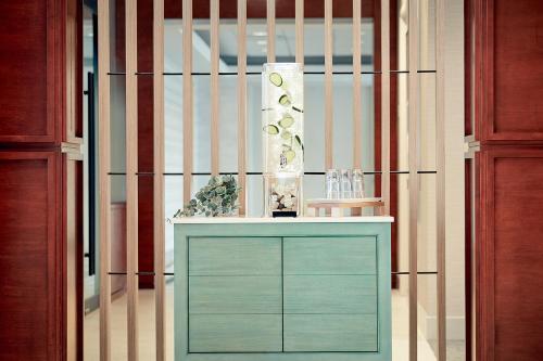 a green cabinet with a vase on top of it at Holiday Inn & Suites Montreal Airport by IHG in Dorval