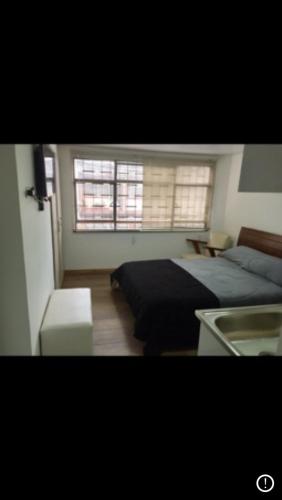 1 dormitorio con 1 cama y 2 ventanas en Apt calle 75 302, en Bogotá