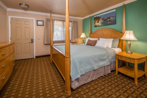 ein Schlafzimmer mit einem Bett mit einem Bettrahmen aus Holz in der Unterkunft Stage Coach Lodge in Monterey