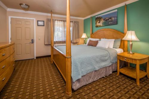 a bedroom with a bed with a wooden bed frame at Stage Coach Lodge in Monterey