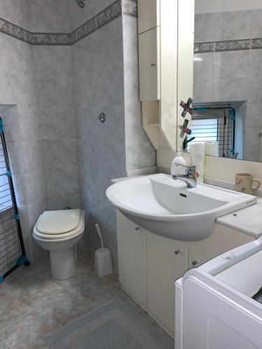 ein Badezimmer mit einem weißen Waschbecken und einem WC in der Unterkunft Appartamenti Paradiso in Macerata