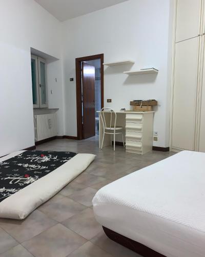 a room with two beds and a desk and a table at Appartamenti Paradiso in Macerata