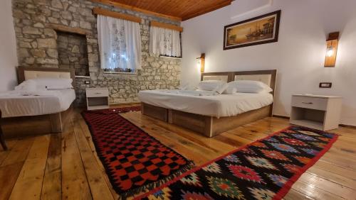 een slaapkamer met 2 bedden en een tapijt bij Dhimitri Apartment in Berat
