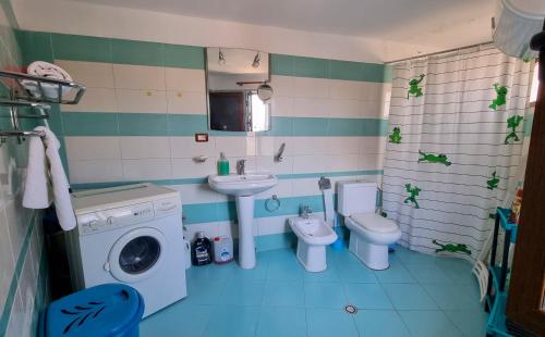 een badkamer met een wasmachine en 2 toiletten bij Dhimitri Apartment in Berat