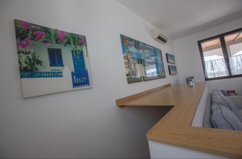 una cocina con fregadero y una barra con flores en la pared en Villa Maldive del Salento, en Marina di Pescoluse