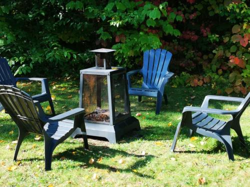 three chairs and a bird house in the grass at Chalet Mont Tremblant Luxury Lodge in Labelle