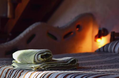 a pile of towels sitting on top of a bed at Alojamiento Ecológico Kurache in Tandil