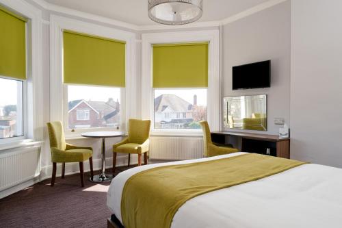 a hotel room with a bed and a table and chairs at St Andrews Hotel in Exeter