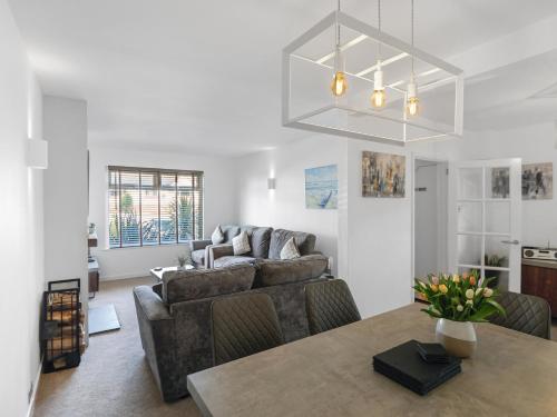 a living room with a couch and a table at Sid Valley View - Scenic end of terrace town house in Sidmouth