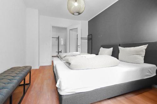 - une chambre avec un grand lit et des draps blancs dans l'établissement Flatista Homes - Central Station - 3BR, à Munich