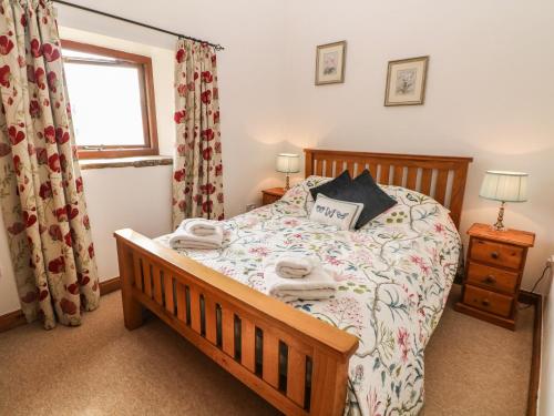 a bedroom with a bed and a window at Midfeather Cottage in Edale