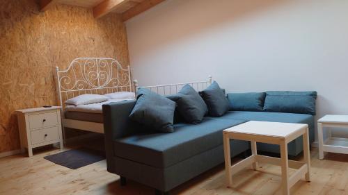 a living room with a blue couch and a bed at Apartamenty STONEHENGE in Sosnowiec