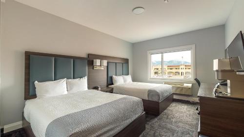 a hotel room with two beds and a window at Park Inn by Radisson Osoyoos in Osoyoos