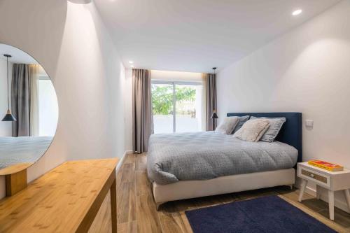 a bedroom with a bed and a large window at Downtown Albufeira 3-Bedroom Luxury Apartment in Albufeira