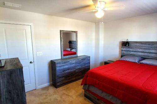Schlafzimmer mit einem roten Bett und einem Spiegel in der Unterkunft New 3 Bedroom Home w/ tons of amenities & parking. in McDonough