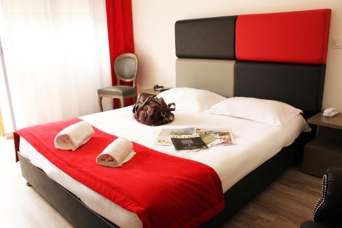 a bedroom with a bed with a red blanket and towels at Adonis Aix en Provence in Aix-en-Provence