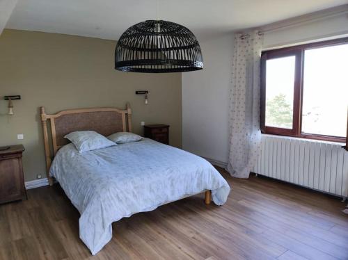 a bedroom with a bed and a large window at Maison Colette au coeur du périgord noir in Montignac