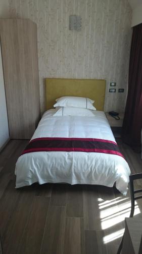 a large bed in a bedroom with a wooden floor at Igiban Hotel in Milan