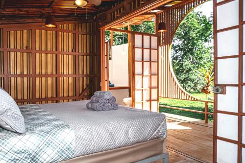 1 dormitorio con 1 cama y puerta abierta en The Mimosas - Beautiful Unique Container Homes with Pool en Hone Creek