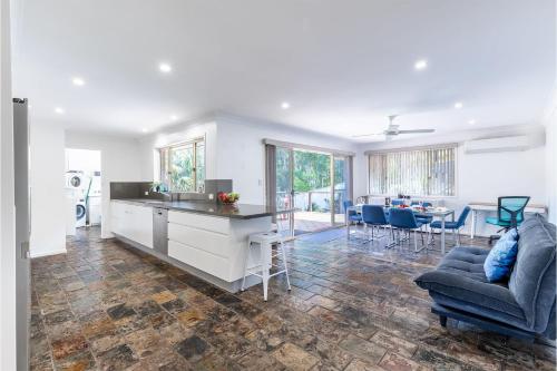 a kitchen and living room with a couch and a table at Kanimbla House 15 Kanimbla Dr - air con, WiFi and pet friendly in Salamander Bay